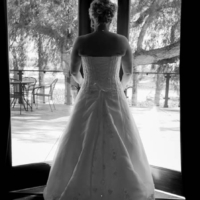 Bride stepping off onto a terrace through glass doors