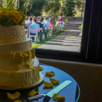 Wedding cake on dessert table overlooking ceremony