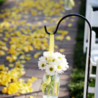 Bouquet if daisies hanging in the aisle at outdoor wedding