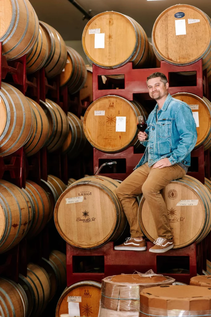 Justin Knight, esteemed winemaker at Danza Del Sol winery in Temecula posing with barrels of wine he has made for the local winery
