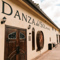 Entrance to Danza del Sol Winery, showcasing the rustic wooden doors and the winery's elegant signage