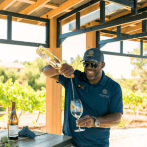 ATV wine tour host pouring wine for guests outdoors near a vineyard